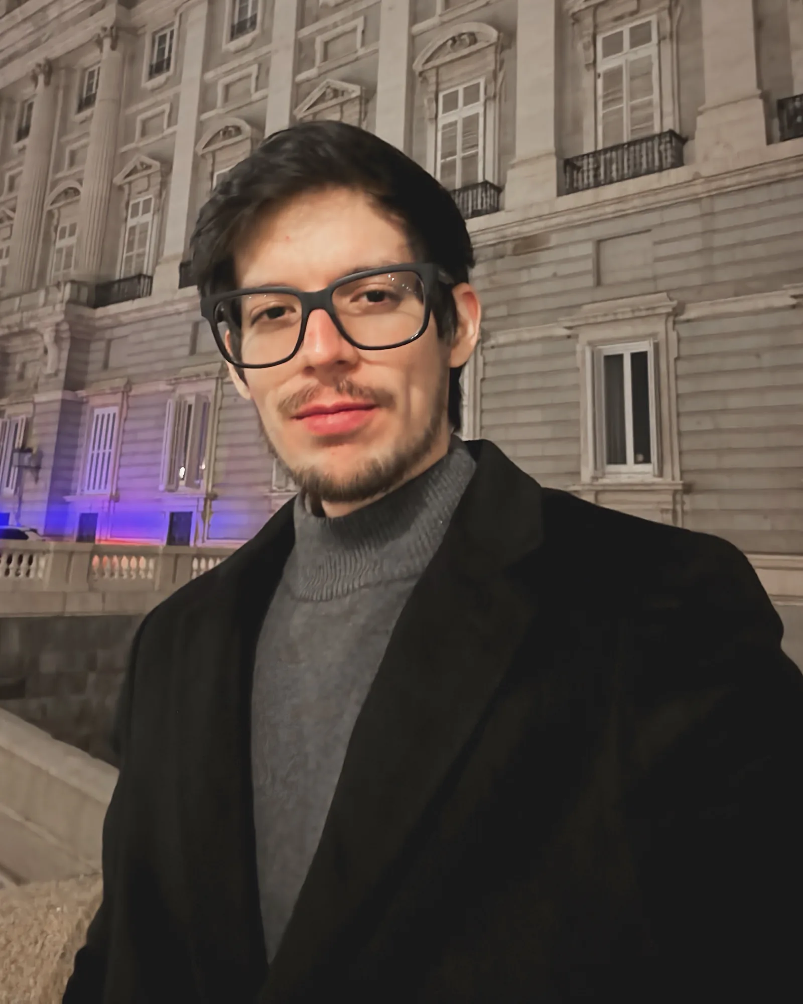Jesús Stalone, retrato nocturno frente a un edificio clásico iluminado